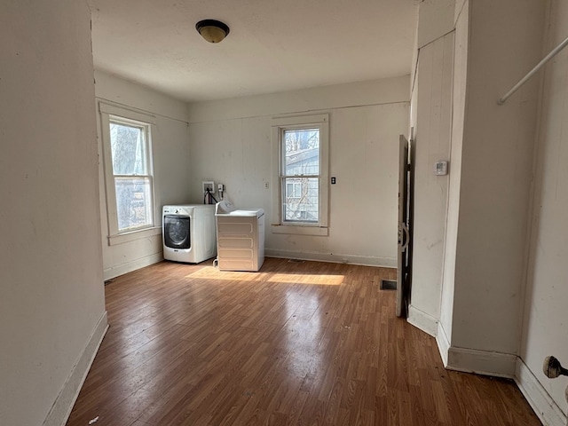 interior space featuring hardwood / wood-style flooring, separate washer and dryer, and a wealth of natural light