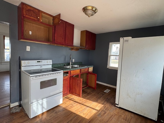 kitchen with sink, white appliances, and dark wood-type flooring