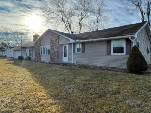 view of front of property featuring a garage, a chimney, and a front yard