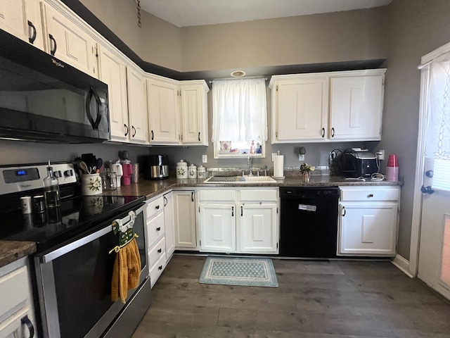 kitchen with black appliances, a sink, dark countertops, white cabinetry, and dark wood-style flooring