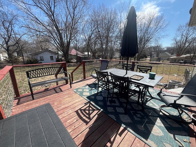 deck featuring outdoor dining area, an outdoor structure, and fence