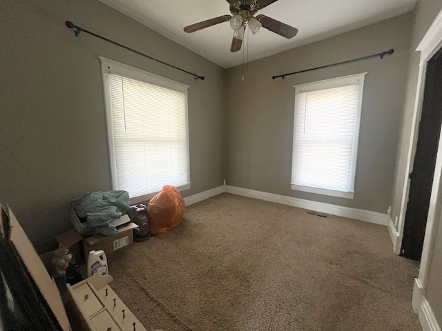 empty room with visible vents, a healthy amount of sunlight, light colored carpet, and baseboards