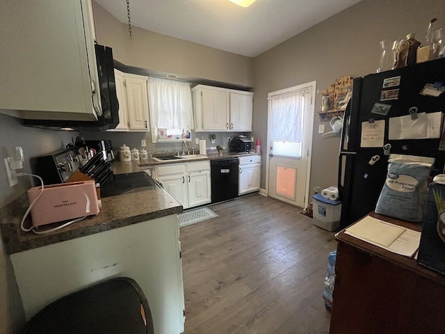 kitchen featuring a sink, black appliances, white cabinets, and a healthy amount of sunlight