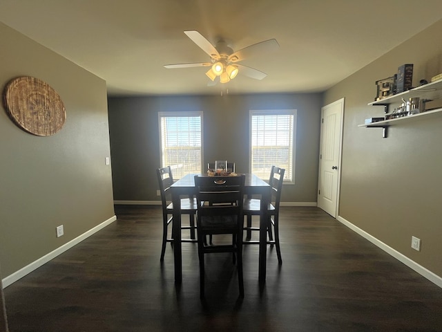 dining area featuring dark wood-type flooring, baseboards, and ceiling fan