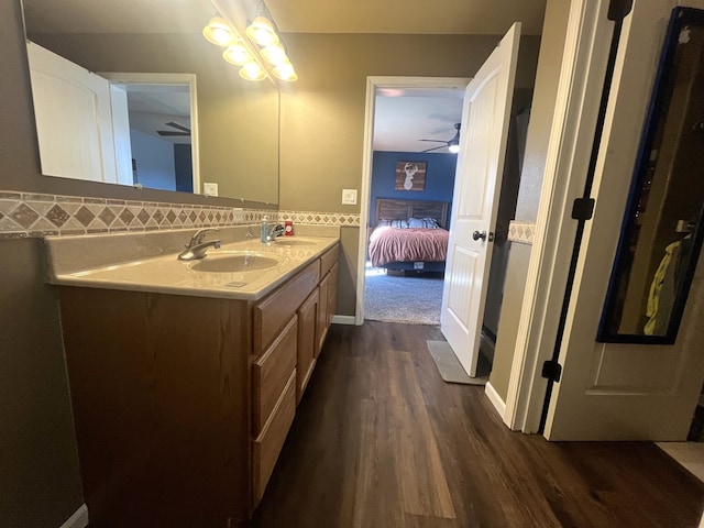 bathroom featuring decorative backsplash, double vanity, wood finished floors, and a sink