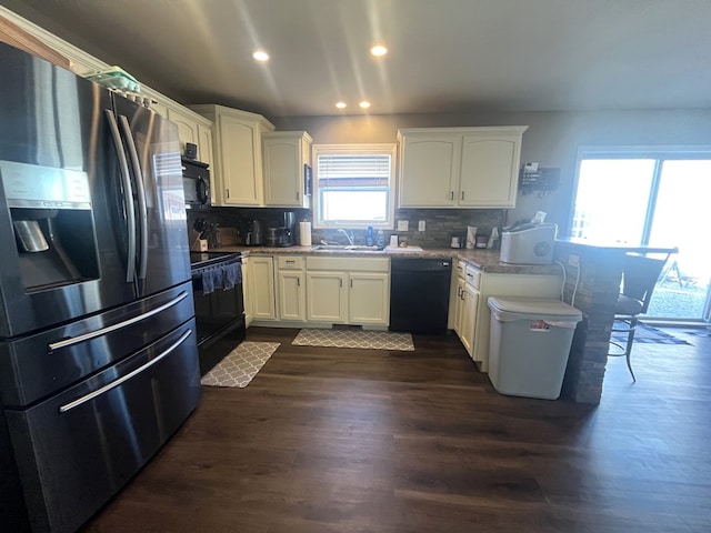 kitchen featuring dark wood finished floors, white cabinetry, a peninsula, and black appliances