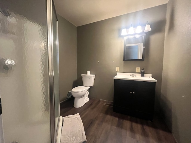 full bath with vanity, toilet, wood finished floors, and a stall shower