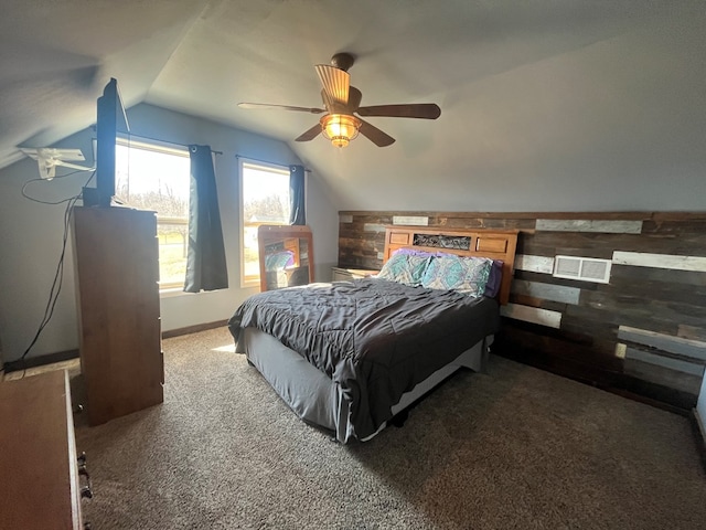 carpeted bedroom with visible vents, baseboards, wood walls, lofted ceiling, and ceiling fan