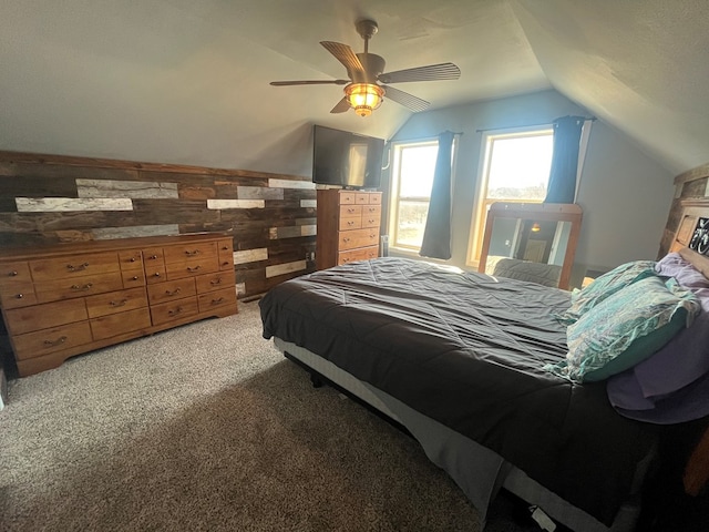 bedroom with light carpet, wood walls, a ceiling fan, and vaulted ceiling