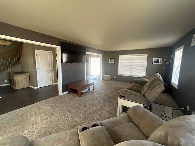 living room featuring carpet flooring, stairway, and baseboards