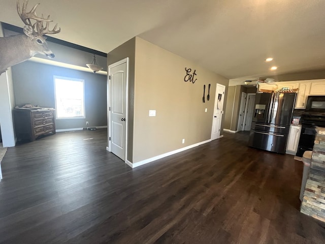 kitchen with black appliances, white cabinets, dark wood-style floors, and baseboards