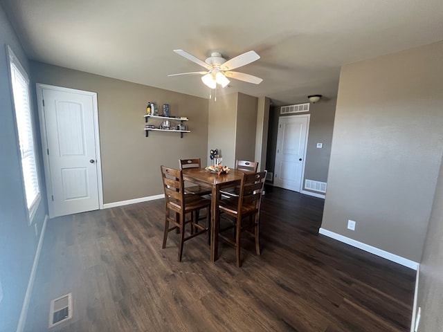 dining space with dark wood-type flooring, baseboards, and visible vents