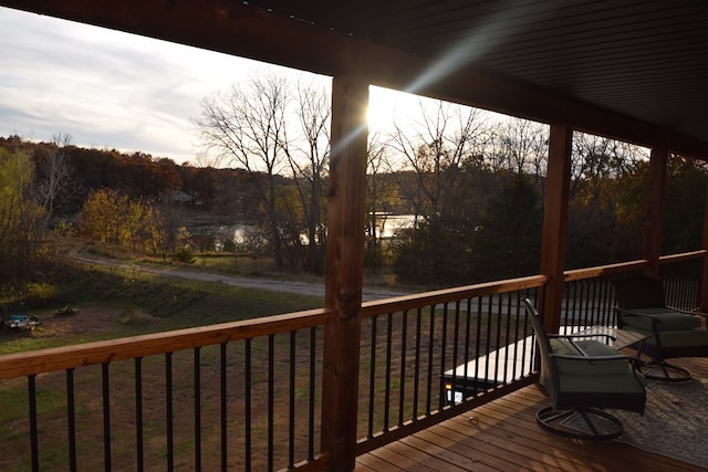 deck at dusk featuring a lawn