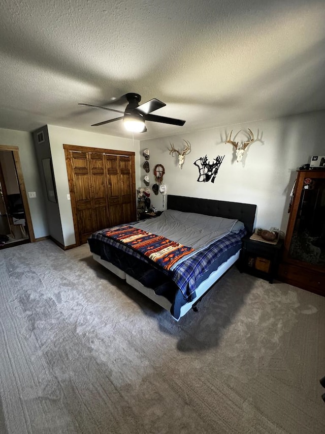 carpeted bedroom featuring ceiling fan and a textured ceiling