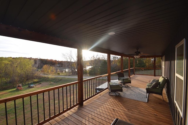 wooden terrace with a lawn and ceiling fan