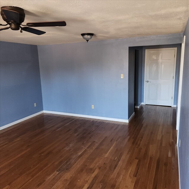 117 N Rollins St, Macon, MO 63552 - spare room featuring baseboards, dark wood-style flooring, and a textured ceiling