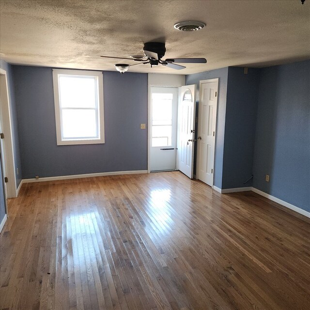 117 N Rollins St, Macon, MO 63552 - unfurnished room featuring hardwood / wood-style flooring, a textured ceiling, a ceiling fan, and a wealth of natural light
