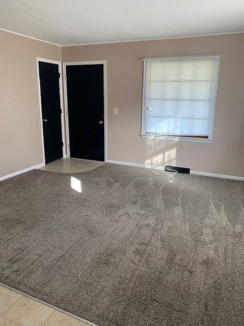 carpeted entrance foyer featuring tile patterned flooring and baseboards