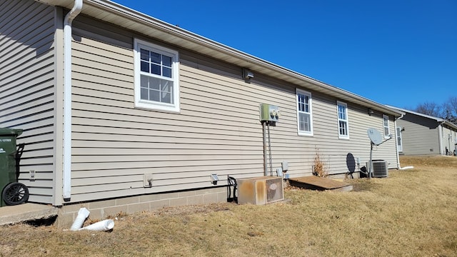 view of home's exterior featuring central air condition unit and a lawn