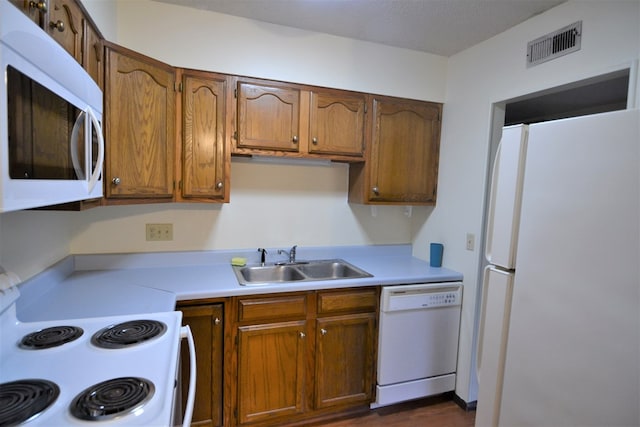 207 Woodwinds Ct, Kirksville, MO 63501 - kitchen with light countertops, white appliances, brown cabinetry, and a sink