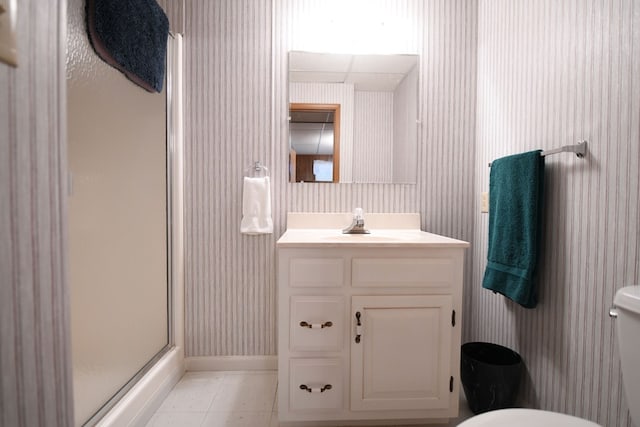 bathroom featuring vanity, toilet, and a shower with shower door