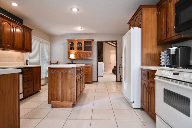 kitchen with a center island, light tile patterned flooring, white appliances, and tasteful backsplash