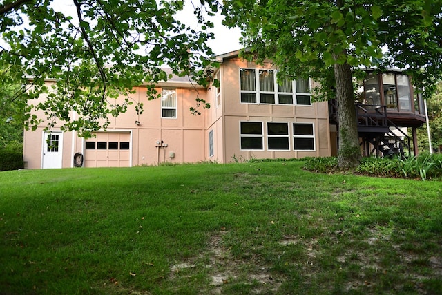 back of house featuring a garage and a lawn