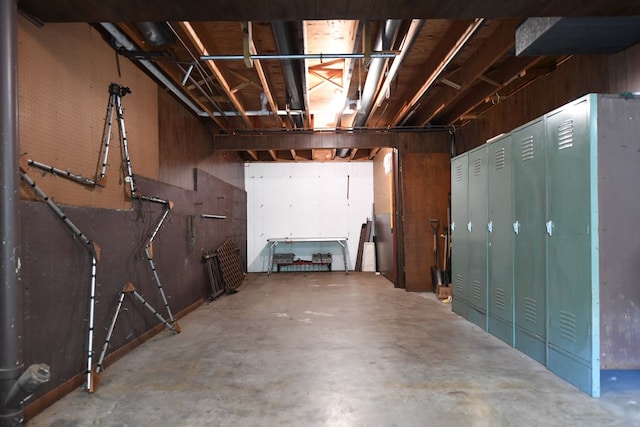 basement featuring wooden walls