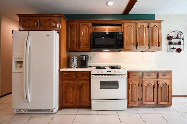 kitchen with light tile patterned flooring, white appliances, a textured ceiling, and tasteful backsplash