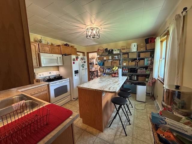 4 Grim Ct N, Kirksville, MO 63501 - kitchen featuring white appliances, a center island, a breakfast bar, light countertops, and brown cabinetry