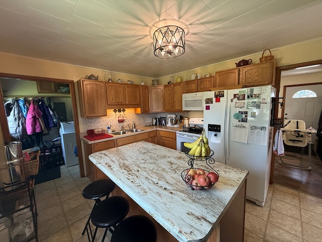 4 Grim Ct N, Kirksville, MO 63501 - kitchen featuring white appliances, washer / dryer, a chandelier, a kitchen island, and brown cabinets