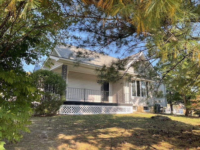 view of side of property with a porch and a lawn