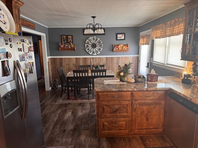 kitchen with a wainscoted wall, stainless steel appliances, dark wood-style flooring, and wooden walls