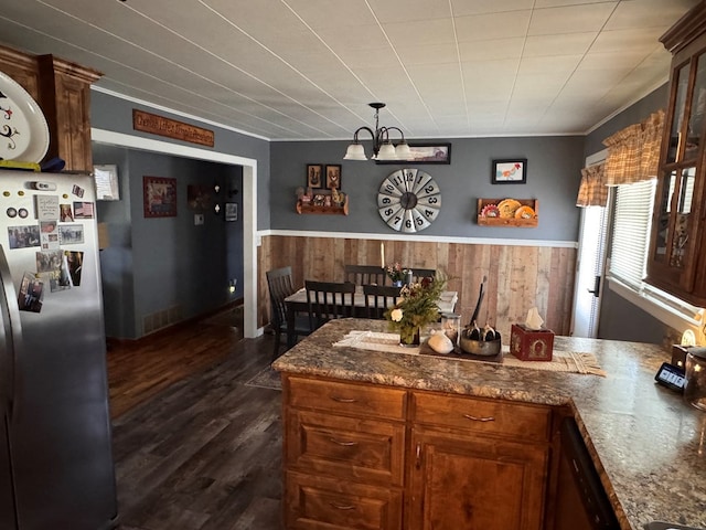 kitchen with wainscoting, wooden walls, dishwasher, and freestanding refrigerator