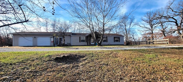 ranch-style home with a garage and a front lawn