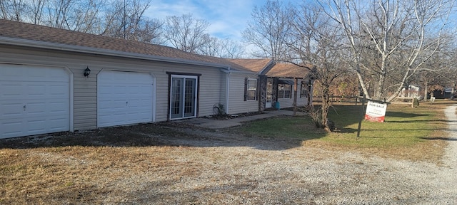 view of side of home featuring a yard and a garage