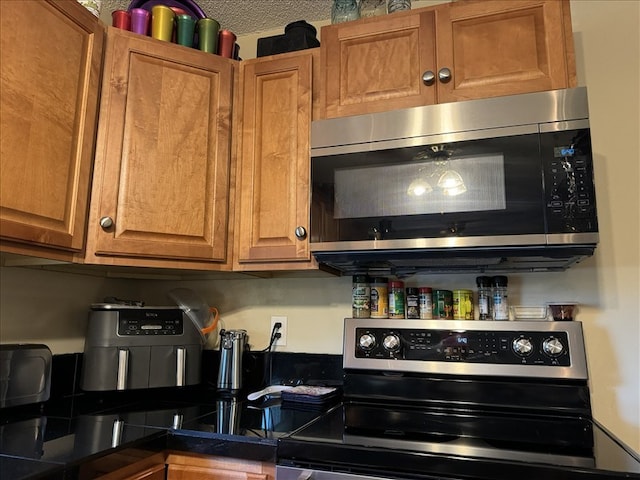 816 Locust St, Macon, MO 63552 - kitchen featuring appliances with stainless steel finishes, brown cabinets, and dark countertops