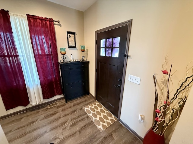 entryway featuring visible vents, baseboards, and wood finished floors