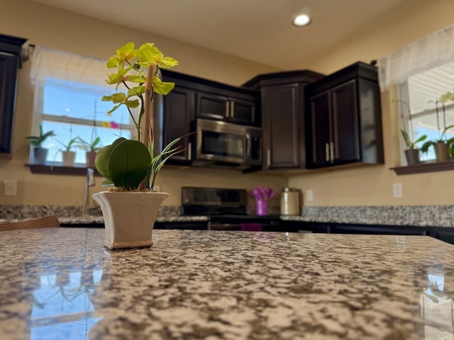 kitchen featuring recessed lighting, stainless steel appliances, and light stone countertops