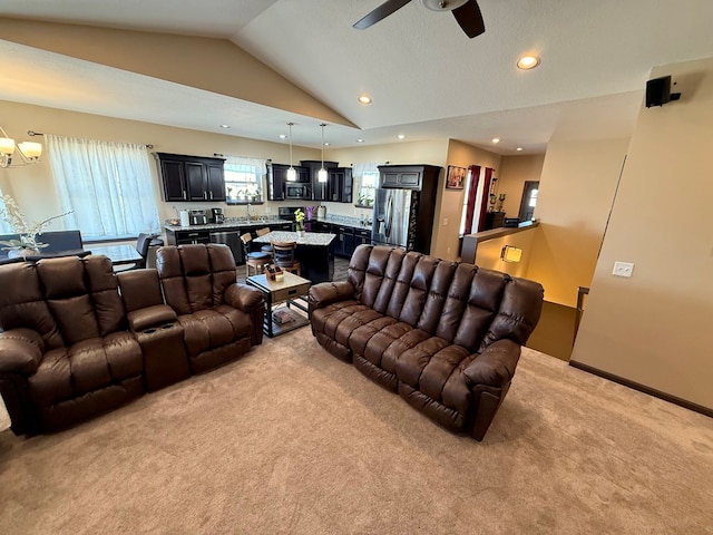 living area featuring baseboards, recessed lighting, vaulted ceiling, light carpet, and ceiling fan with notable chandelier