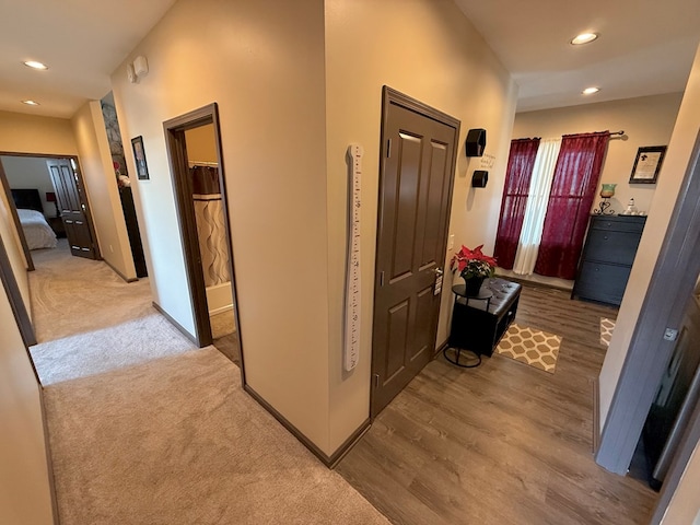 hallway featuring recessed lighting, baseboards, and wood finished floors