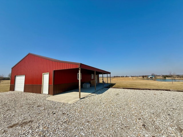 view of pole building featuring a yard and a water view