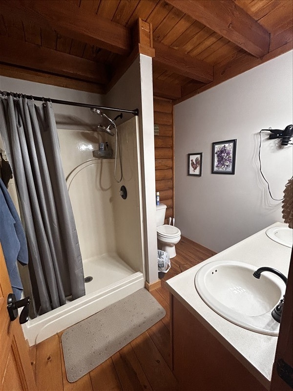 28730 State Highway T, Excello, MO 65247 - bathroom with a wooden ceiling with exposed beams, wood finished floors, curtained shower, double vanity, and log walls