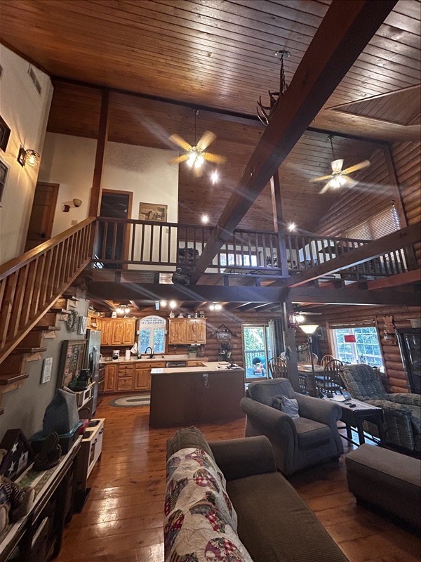 28730 State Highway T, Excello, MO 65247 - living area with a ceiling fan, high vaulted ceiling, a wood ceiling with exposed beams, dark wood-style flooring, and stairway
