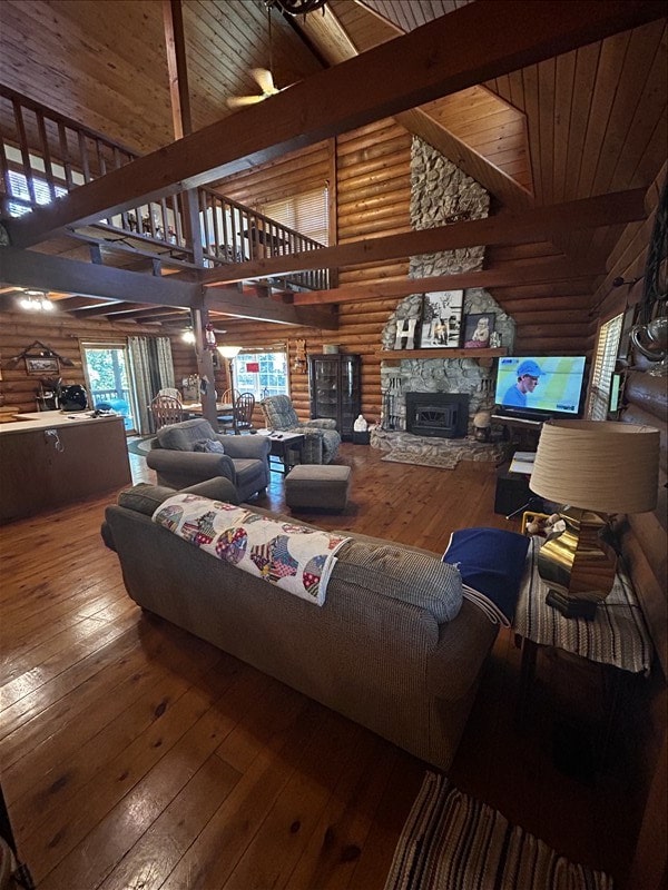 28730 State Highway T, Excello, MO 65247 - living room featuring high vaulted ceiling, wood-type flooring, a fireplace, a wood ceiling with exposed beams, and log walls