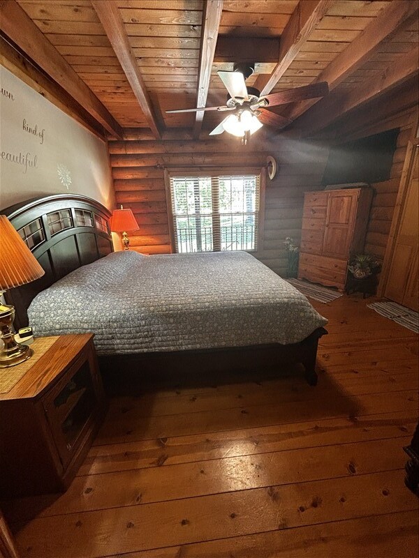 28730 State Highway T, Excello, MO 65247 - bedroom with log walls, hardwood / wood-style floors, and a wood ceiling with exposed beams