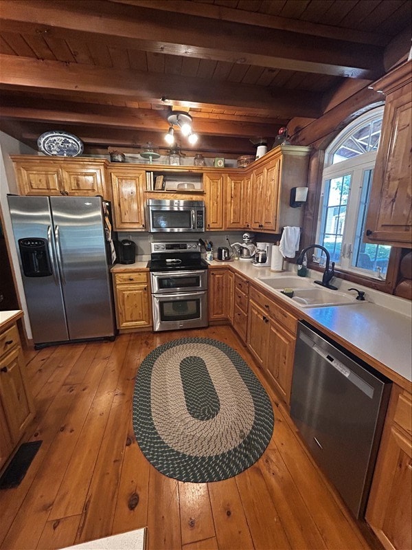 28730 State Highway T, Excello, MO 65247 - kitchen featuring appliances with stainless steel finishes, light wood-style flooring, light countertops, a wood ceiling with exposed beams, and brown cabinets