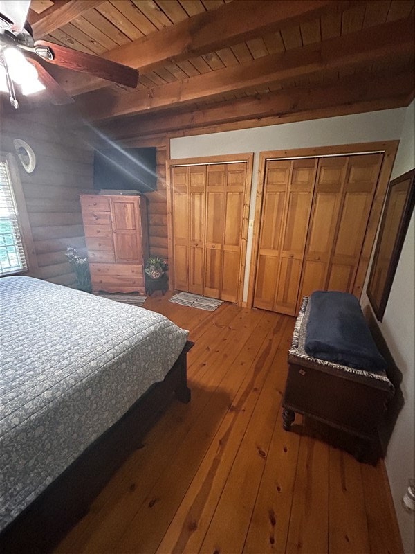 28730 State Highway T, Excello, MO 65247 - bedroom with multiple closets, light wood-type flooring, a wood ceiling with exposed beams, and log walls