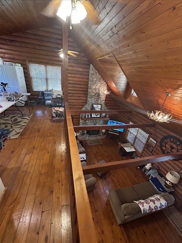 28730 State Highway T, Excello, MO 65247 - living area with wooden ceiling, vaulted ceiling, rustic walls, hardwood / wood-style flooring, and ceiling fan