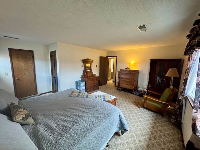 carpeted bedroom with visible vents and a textured ceiling